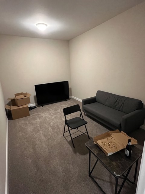 a sparsely furnished room with a sofa and a TV on the floor